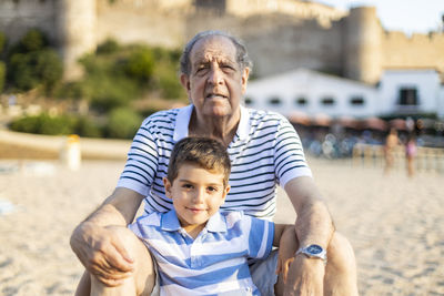 Portrait of grandfather and grandson at beach