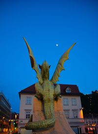 Low angle view of statue against blue sky