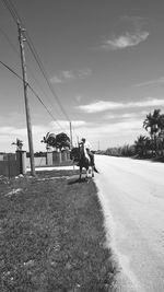 People on road against cloudy sky