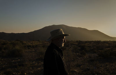 Adult man in cowboy hat on tabernas desert during sunset. almeria, spain