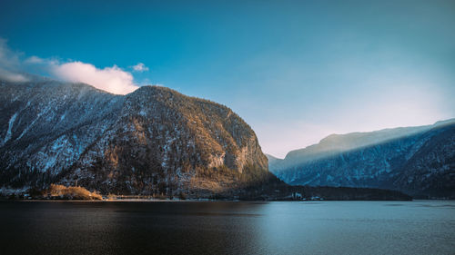 Scenic view of lake by mountains against sky