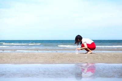 Full length of boy on beach against sky