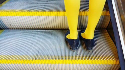 Low section of woman on escalator