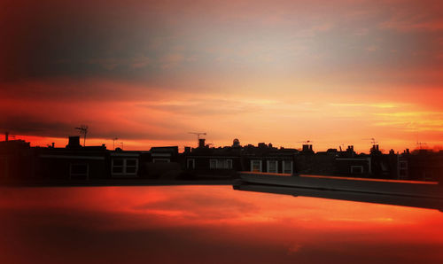Silhouette buildings against sky during sunset