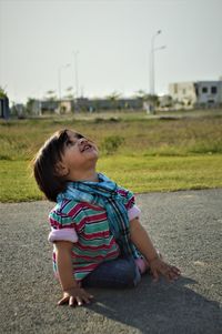 Side view of girl sitting on field