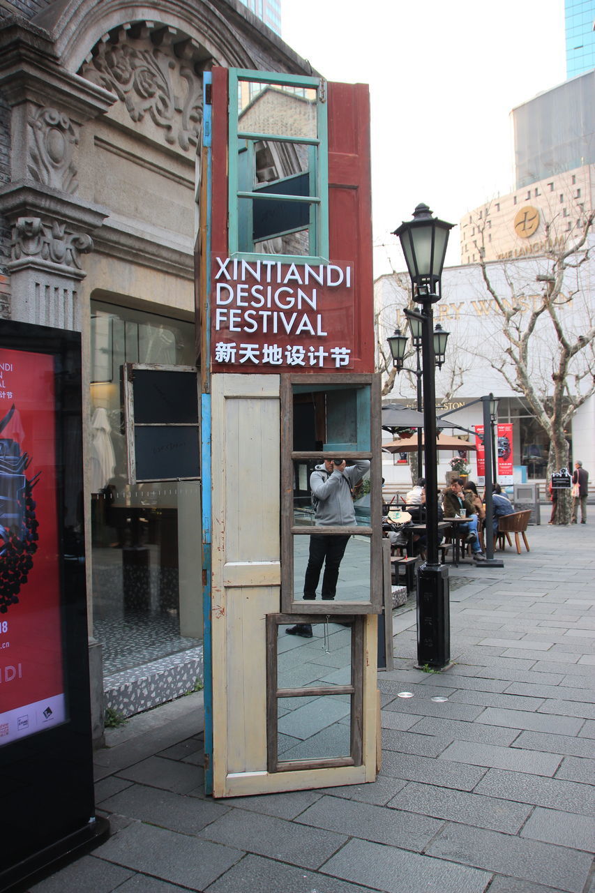 MAN WITH TEXT IN FRONT OF BUILDING