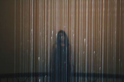 Woman standing behind plastic curtain