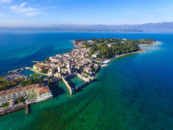 High angle view of townscape amidst sea against sky