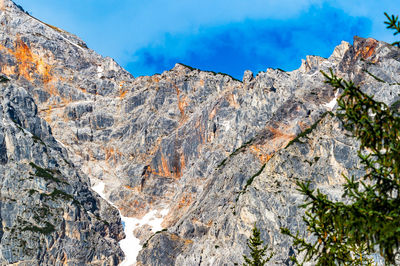 Low angle view of rocky mountains against sky