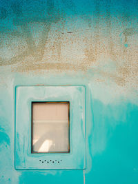 Close-up of window on blue wall