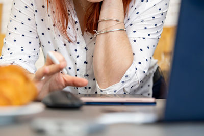 Midsection of woman holding umbrella on table