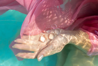 High angle view of woman holding crystal in swimming pool