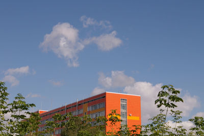 High section of buildings against blue sky and clouds