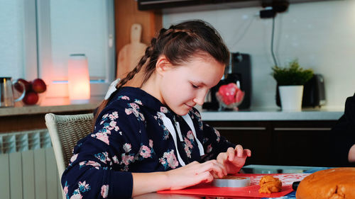 Side view of young woman holding food at home