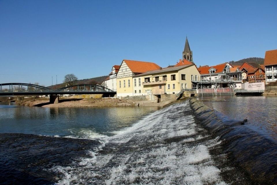 architecture, built structure, building exterior, clear sky, water, blue, copy space, river, waterfront, canal, incidental people, sunlight, bridge - man made structure, city, day, house, residential structure, outdoors, reflection, connection