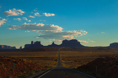 Road amidst landscape against blue sky