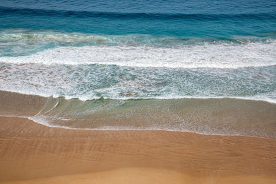 High angle view of waves rushing towards shore