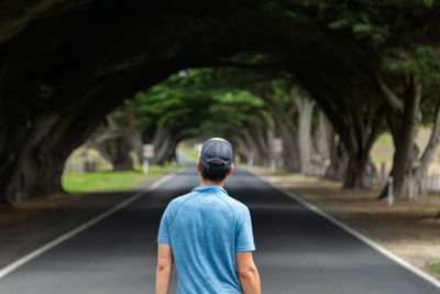 Rear view of man walking on road