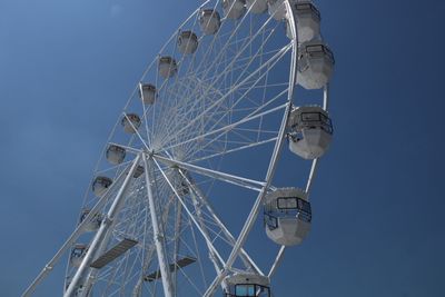 Low angle view of ferris wheel against blue sky