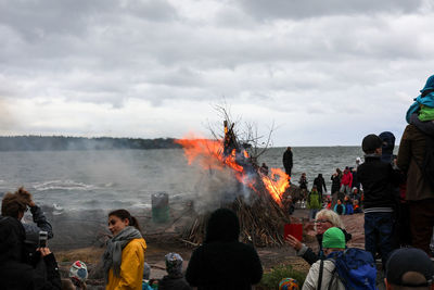 Group of people on beach against sky