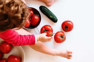 High angle view of baby with crushed tomatoes on table