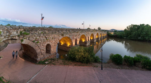 Arch bridge over river against sky