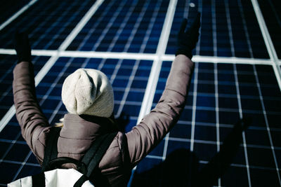 High angle view of woman in warm clothing by solar panel