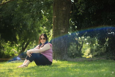 Woman sitting on tree trunk