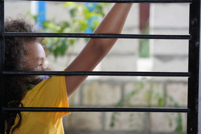 Rear view of woman standing against railing