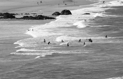 People surfboarding in sea