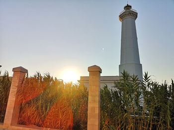 Low angle view of lighthouse by building against sky