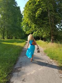 Rear view of woman walking on footpath at park