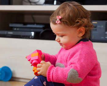 Cute girl holding toys at home