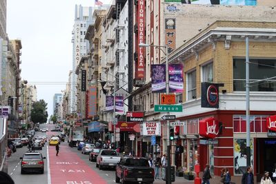 Cars on street amidst buildings in city