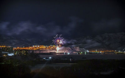 Illuminated cityscape against sky at night