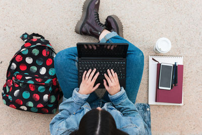 Top view of a university student while she writes in her laptop