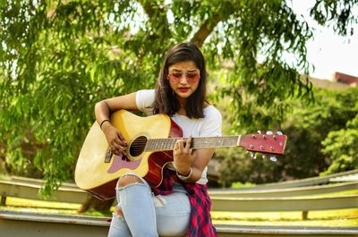 Full length of a woman playing guitar