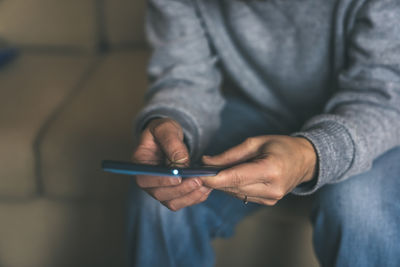 Midsection of man using mobile phone