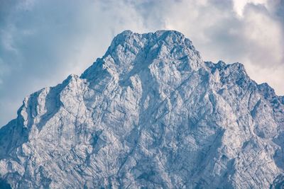 Low angle view of snowcapped mountains against sky