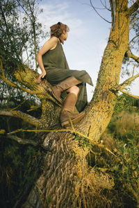 Woman sitting on a tree