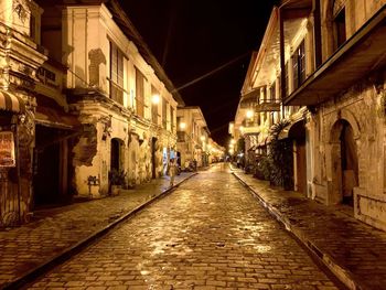 Street amidst buildings at night