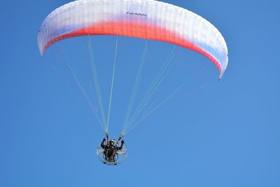 Low angle view of paragliding against clear sky