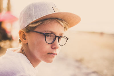 Close-up of boy wearing cap looking away