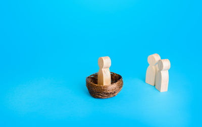 Close-up of wooden figurine against blue background