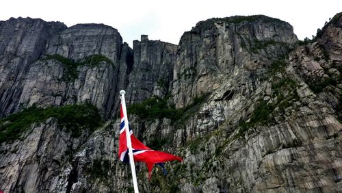 Low angle view of flags on mountain against sky