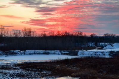 Snow covered field at sunset