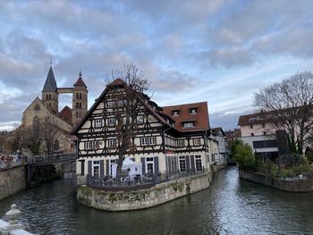 River amidst buildings in city against sky