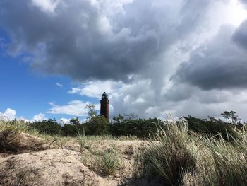 Lighthouse on landscape against sky