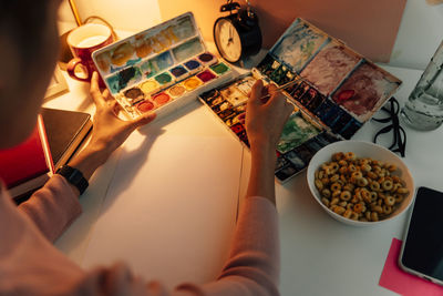 High angle view of woman holding food on table