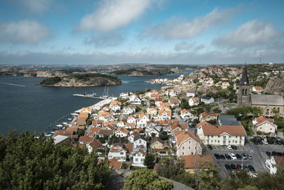 High angle view of townscape by sea against sky